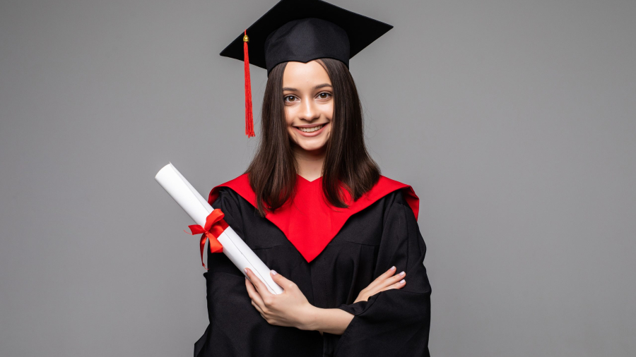 Happy student with graduation hat and diploma on grey background. Space for text